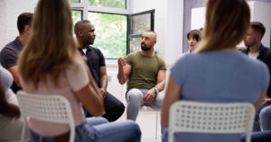 man talking to group about the addiction recovery process