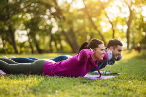Man and woman in park doing yoga
